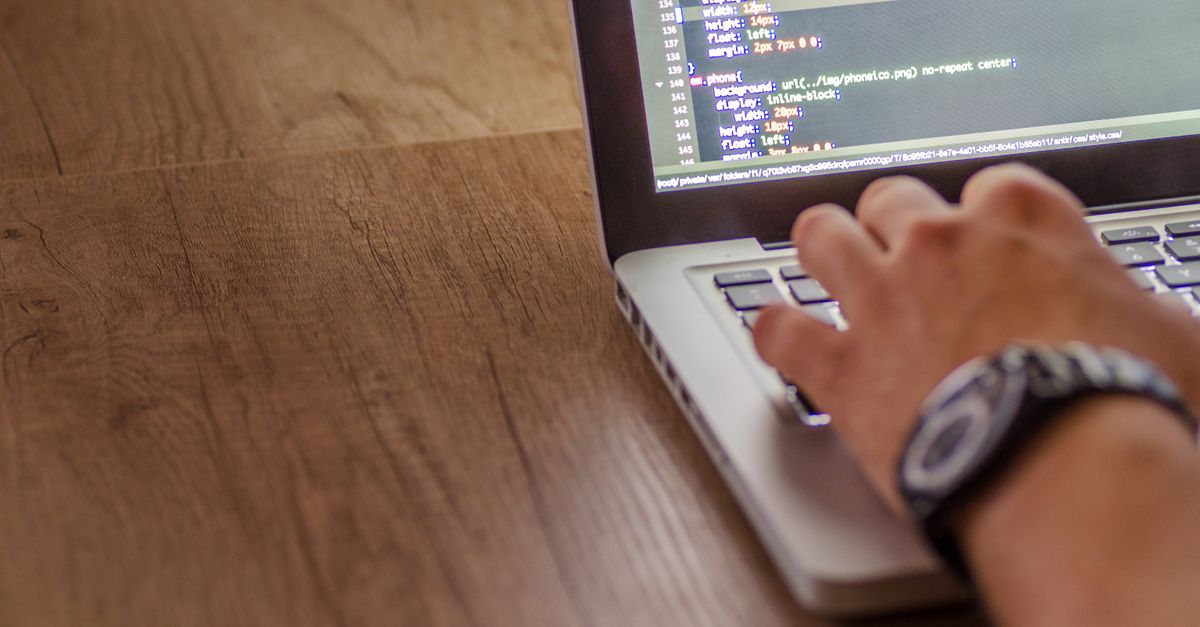 A small business owner reviewing their own website with a printed audit checklist.